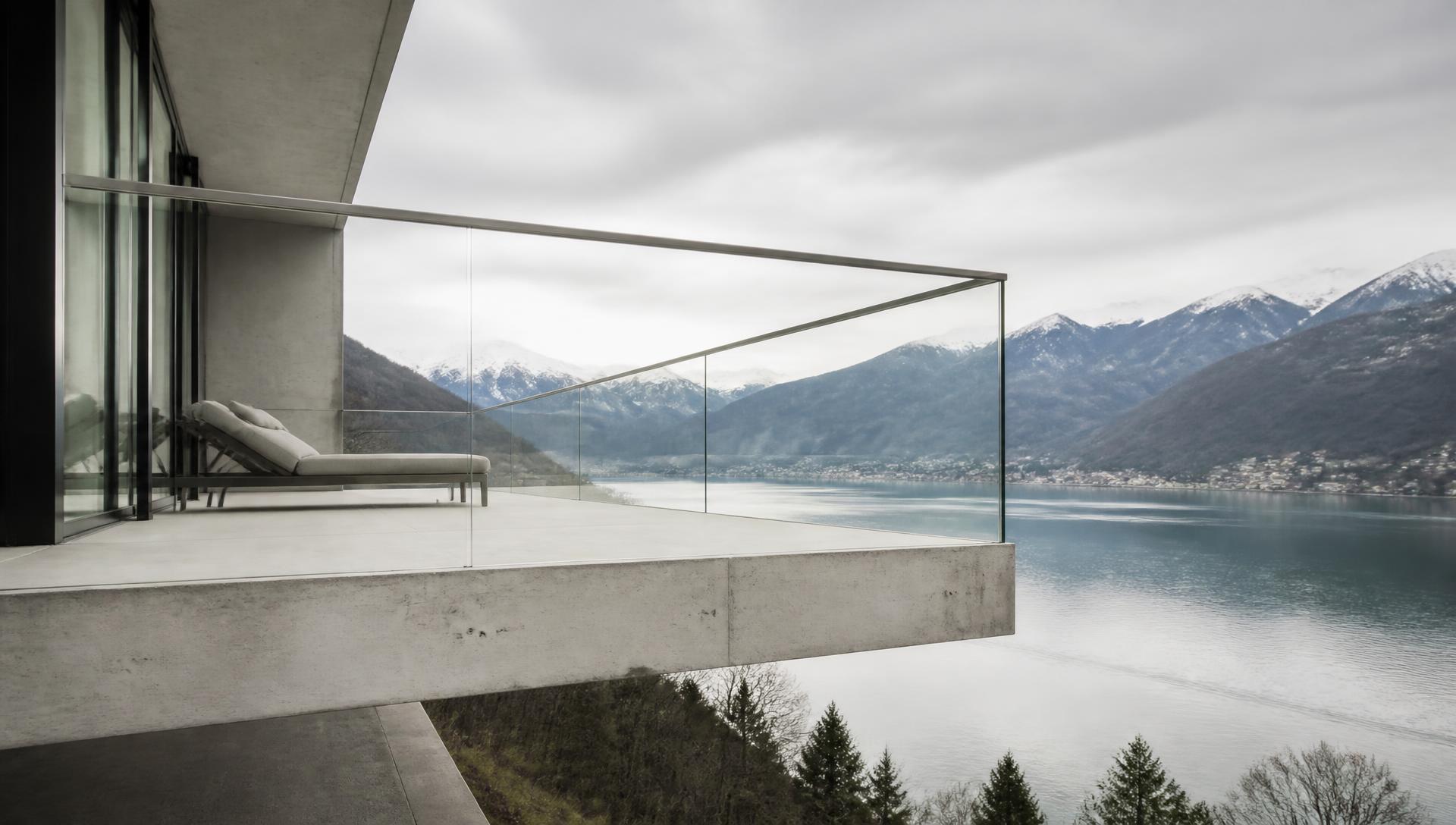 Parapetto in vetro strutturale su terrazza moderna, vista lago al crepuscolo